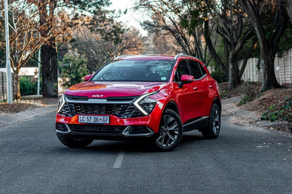 red kia sportage SUV on a road in the UK.